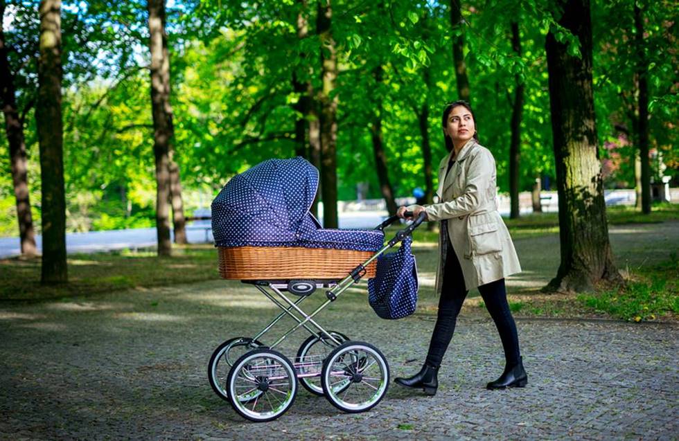 Spacer z dzieckiem w wiklinowym wózku retro – symbol slow parenting i życia w zgodzie z naturą